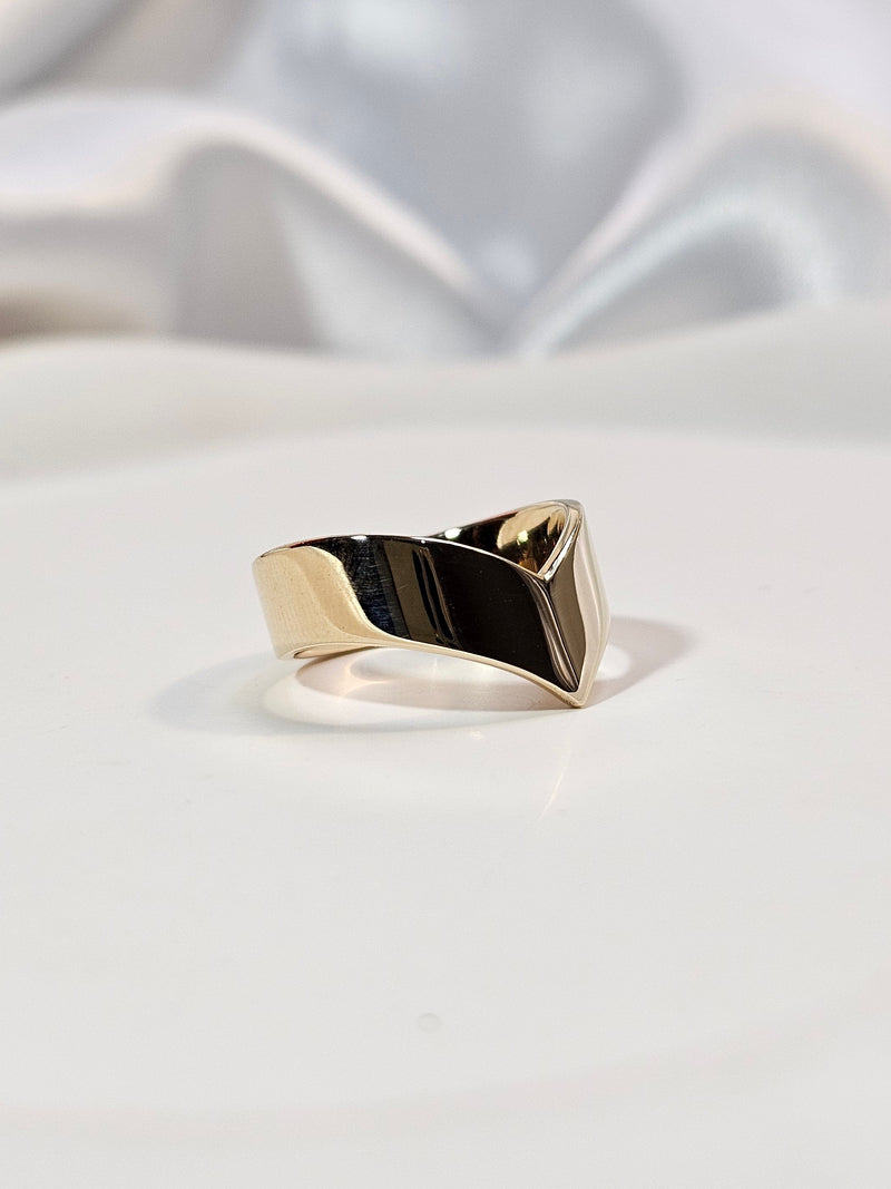 A modern geometric ring with a polished gold band 