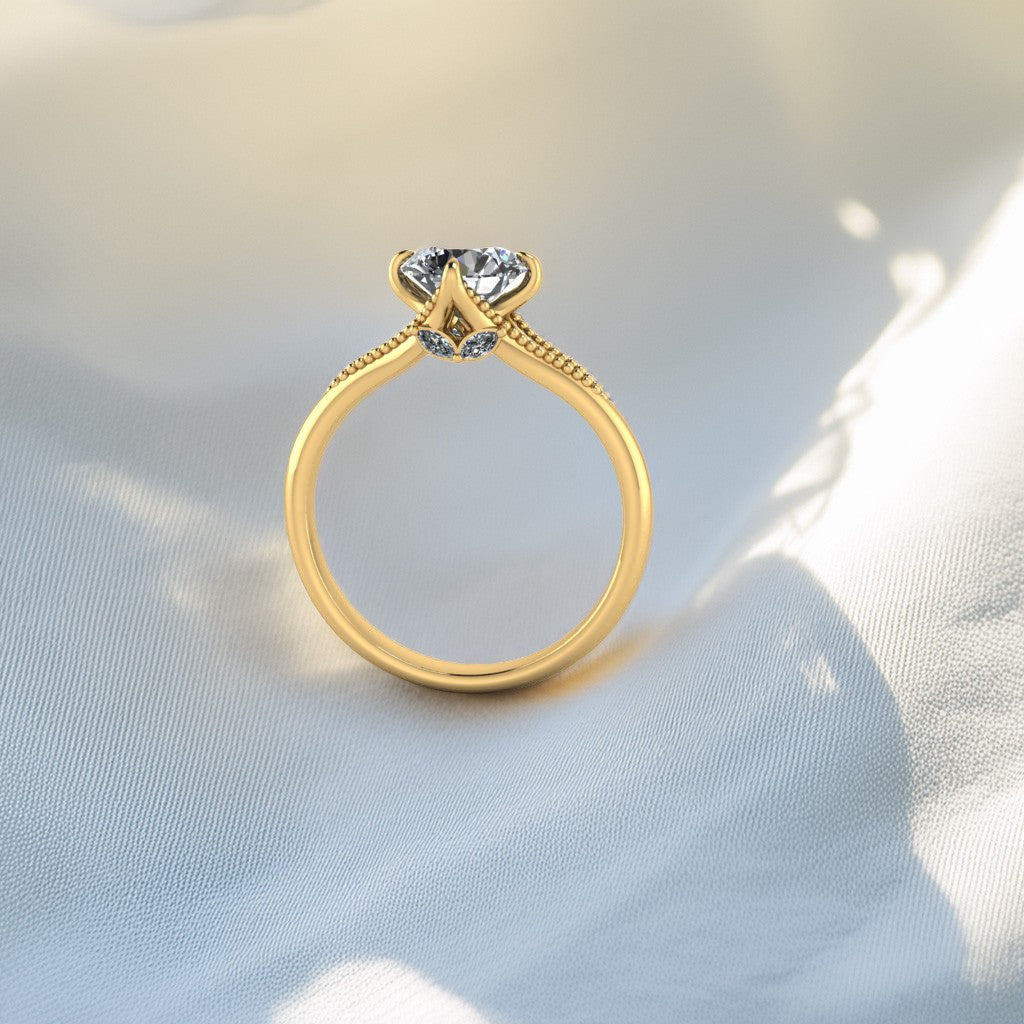 Gold ring with a heart-shaped diamond on a light fabric background
